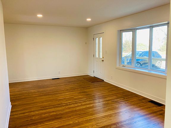 Large front living room area with recessed lights and bay window.