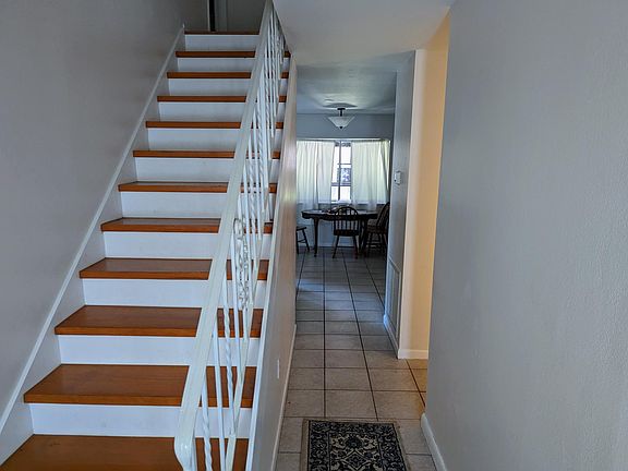 Stairway near front door with view to dining area