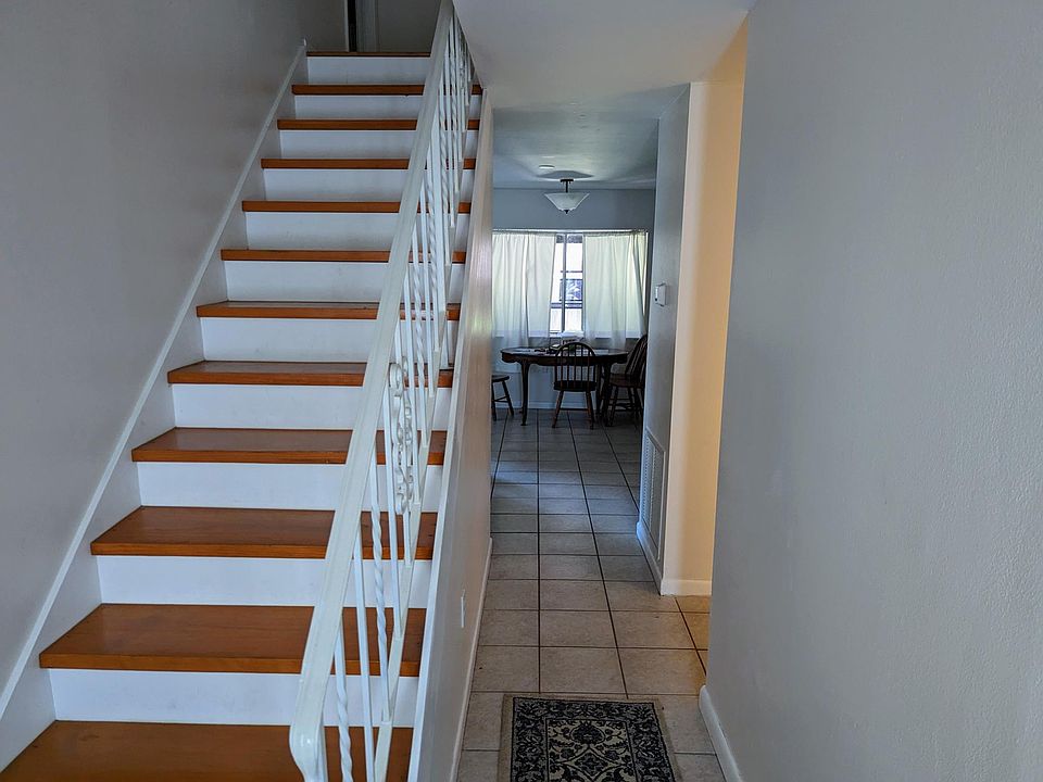 Stairway near front door with view to dining area