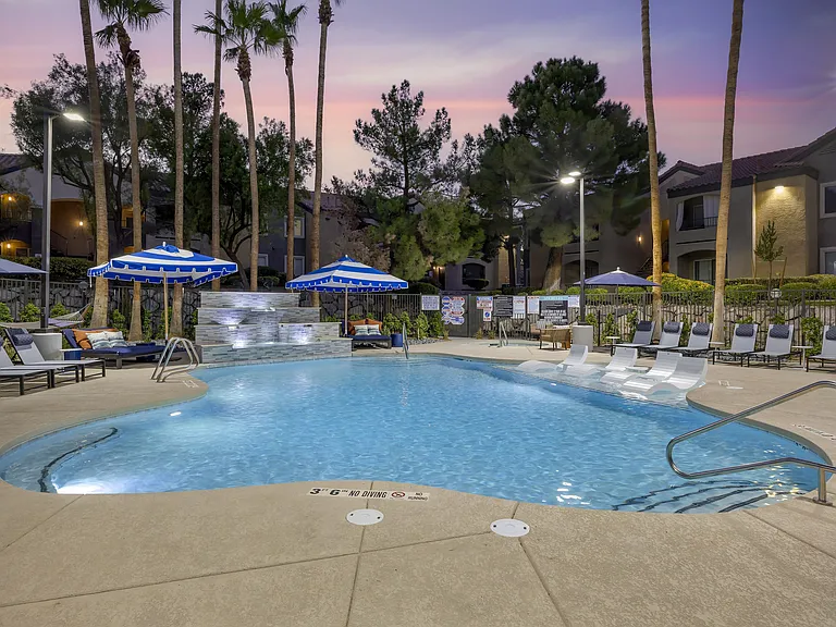 The shimmering water reflects the colors of the sunset, creating a serene atmosphere perfect for unwinding after a long day at our updated pool.