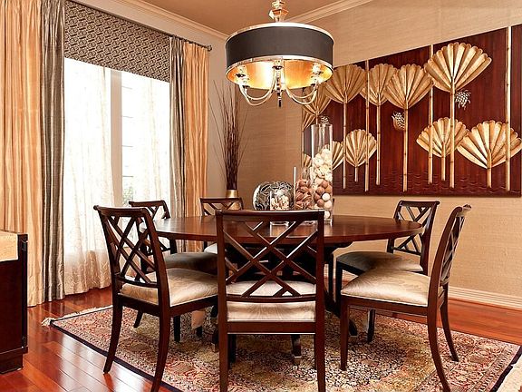 Formal Dining room features a gorgeous light fixture, custom paint and grass wallpaper on the accent wall. The Study is across the hall with access through French Doors.