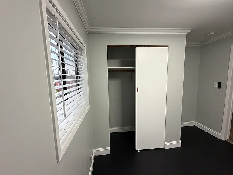Bedroom 2 with modern ceiling fan, spacious closet, and room beside the closet for a dresser or desk.