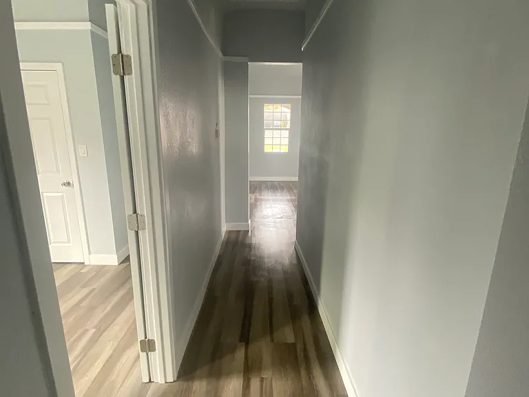 Hallway from Back to Front of Apartment, Bedroom 2 to the left