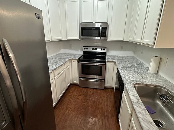White updated Kitchen with white subway tile and marble countertops.