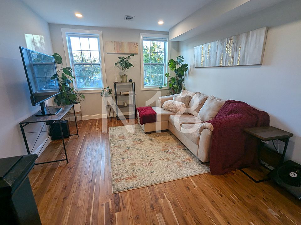 Living room on main level with plenty of natural light and blackout electric blinds