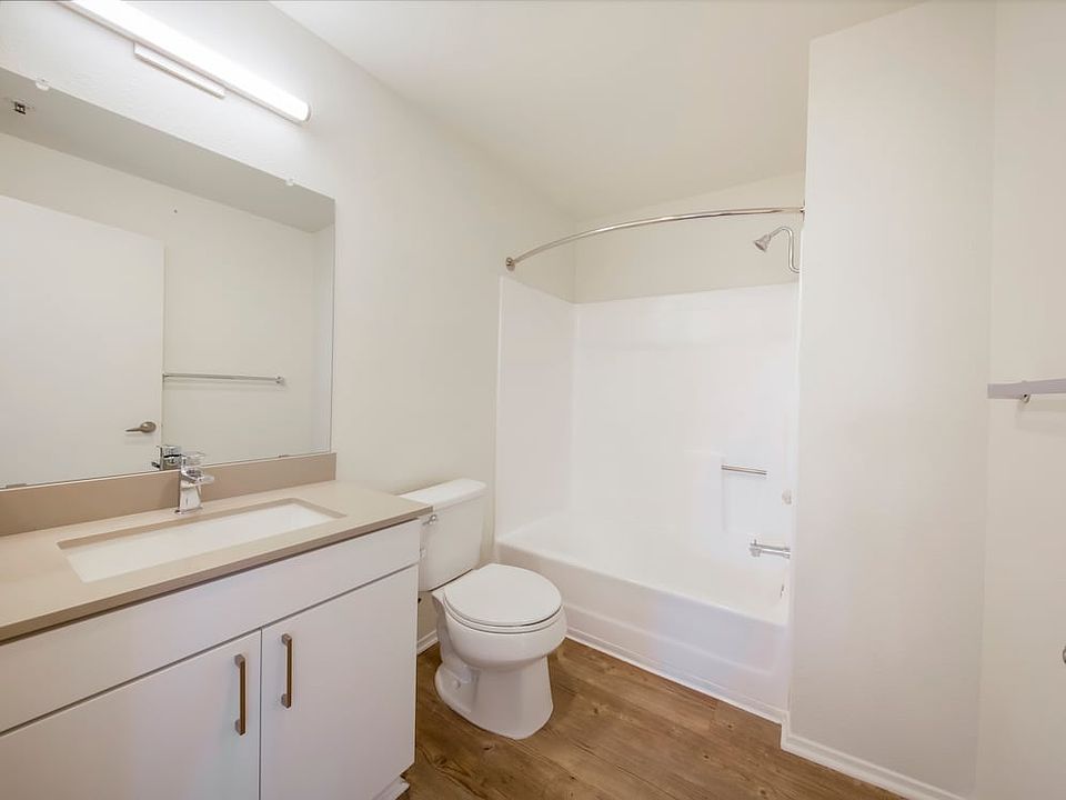 Renovated Package Bath with white cabinetry, grey quartz countertop, and hard surface flooring