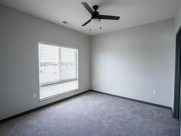 Large bedroom with carpet and ceiling fan at The Harbor.