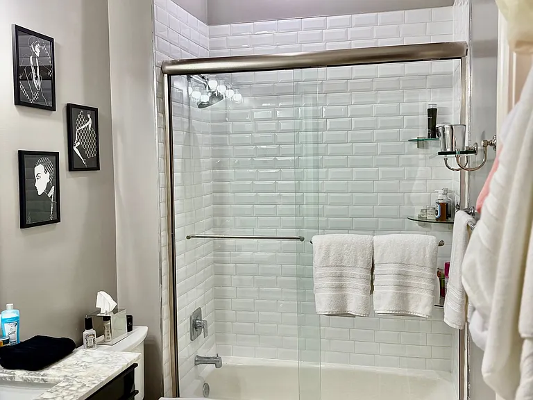 Bath w/ Tub and Shower. Heavy Glass Shower Door w/ Stainless Trim. Recessed Lighting above Shower. Chair Height Kohler Toilet.