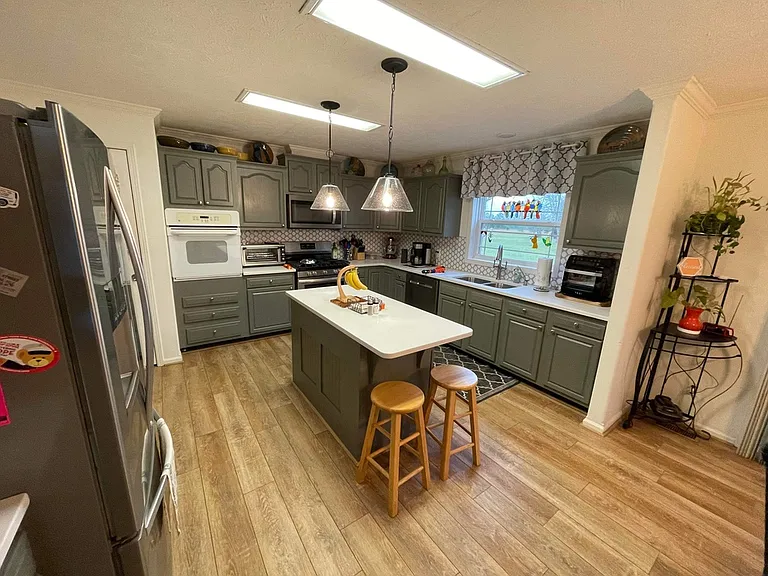 Kitchen has two ovens; one electric in the wall, the other gas has a 5 burner range top. Microwave with vent that goes outdoors above the oven. Very quiet dishwasher and deep sink. Small brunch bar. Reverse osmosis filter water faucet in sink.