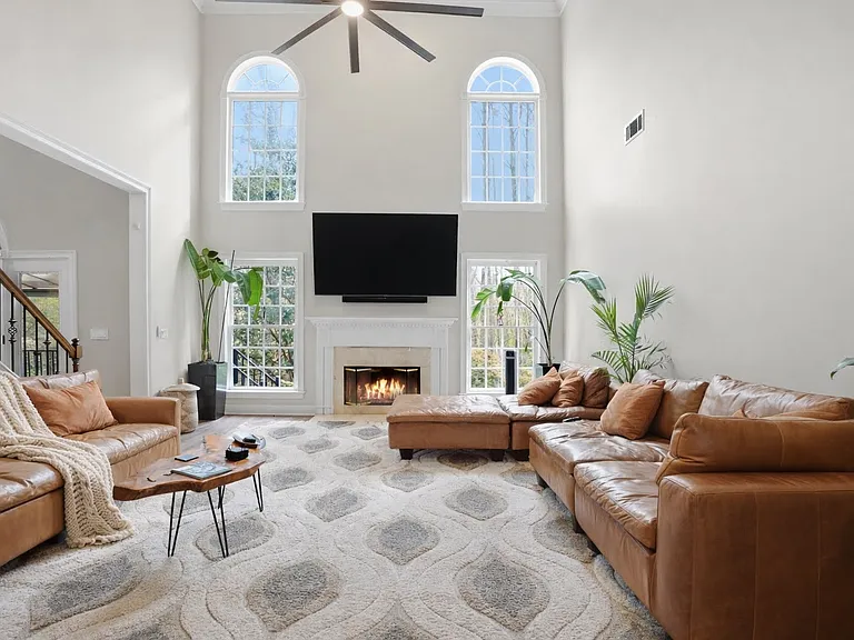 Light-filled living area with soaring ceilings and a fireplace for everyday comfort