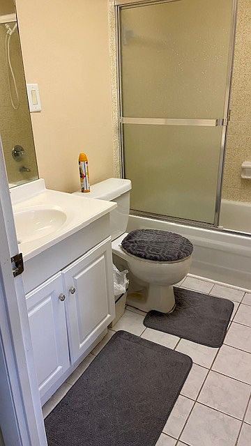 Updated bathroom with safety handle in enclosed tub.