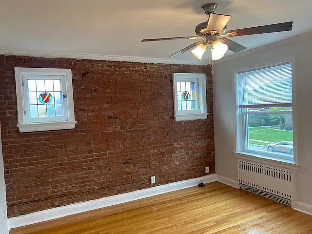 Exposed brick, new windows, and ceiling fan in the living room