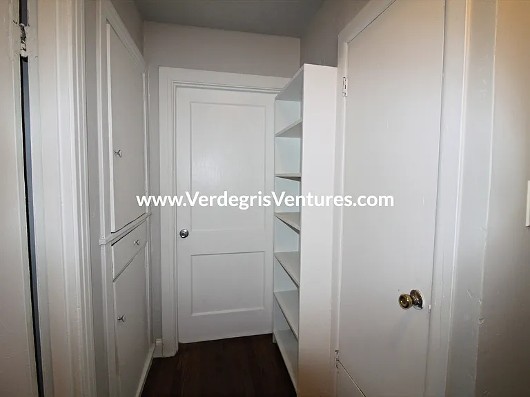 hallway includes built in cabinets and shelving for added storage