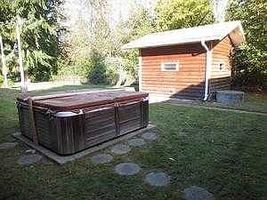 Backyard showing hot tub & well house