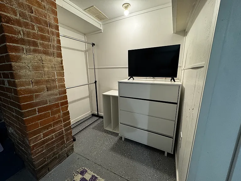 Bedroom 4 hanging clothes and dresser with Smart TV