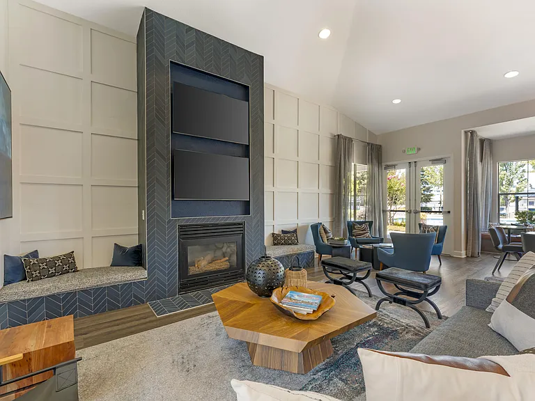 The clubhouse features dual TVs and a cozy fireplace, creating a warm and inviting space for residents to relax and socialize at Ascent at the Galleria.
