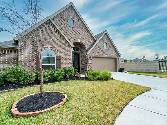 This home is adorned by flowerbeds and lush foliage that offers great curb appeal.