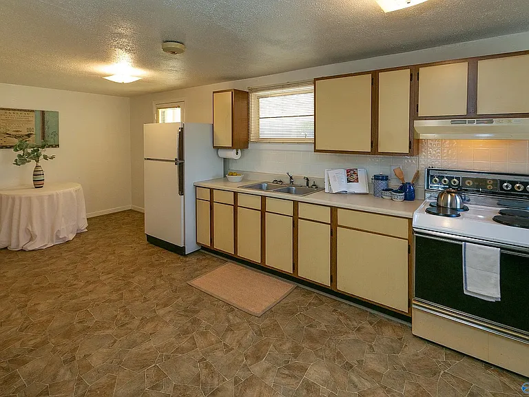 Opposite view of kitchen, except the kitchen now ends at the end of the cabinets where the refrigerator (not there anymore) begins. That area where the refrigerator & table are is now the 3rd bedroom.