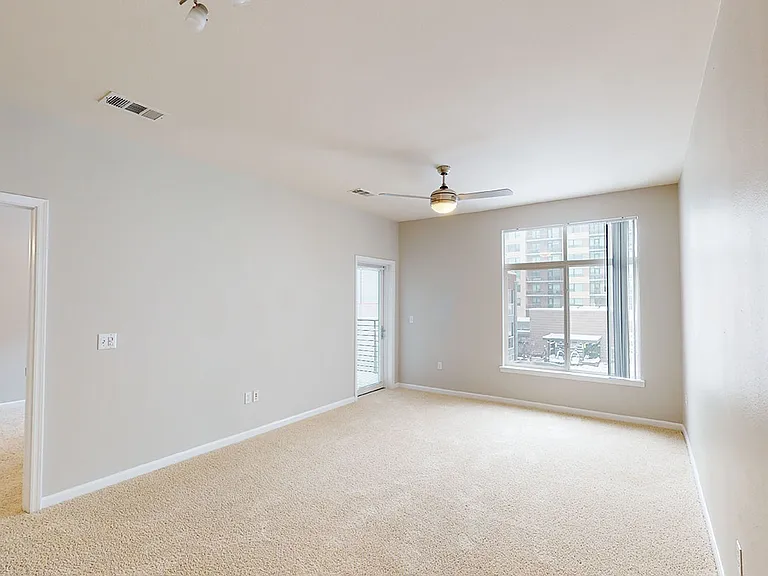 Apartment living room with plush carpet flooring and patio or balcony in select homes.
