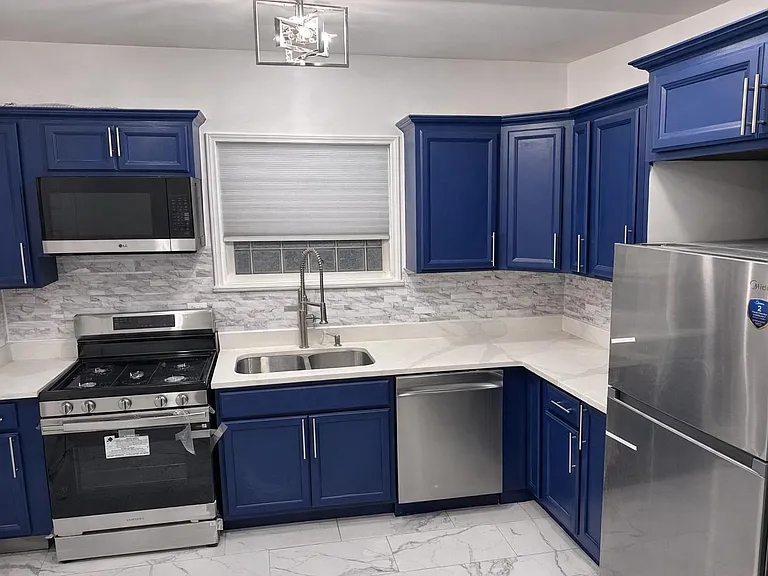 Spotless kitchen with stainless steel stove, microwave, dishwasher, and refrigerator. Coffee maker, slow cooker, air fryer.