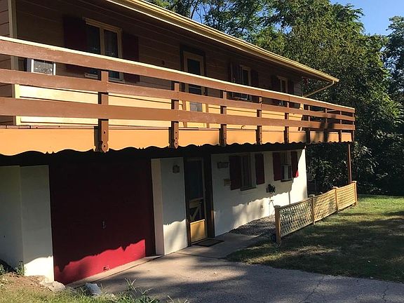 Wraparound balcony overlooks woods and stream.