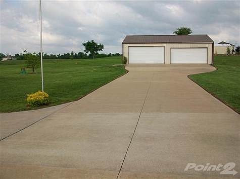 Detached 4 car workshop has cement floor, insulation, electricity and is Dish TV ready. Additional level parking pad behind it.