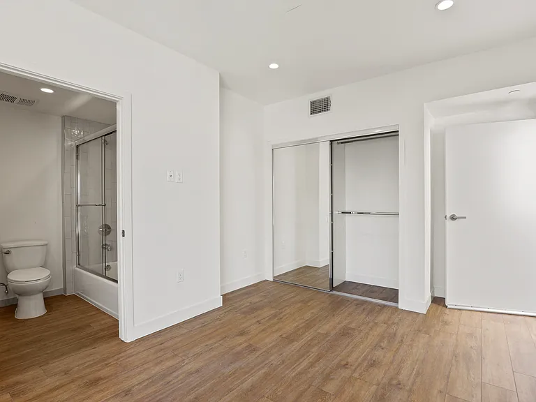 Bedroom with a Mirrored Closet and Bathroom
