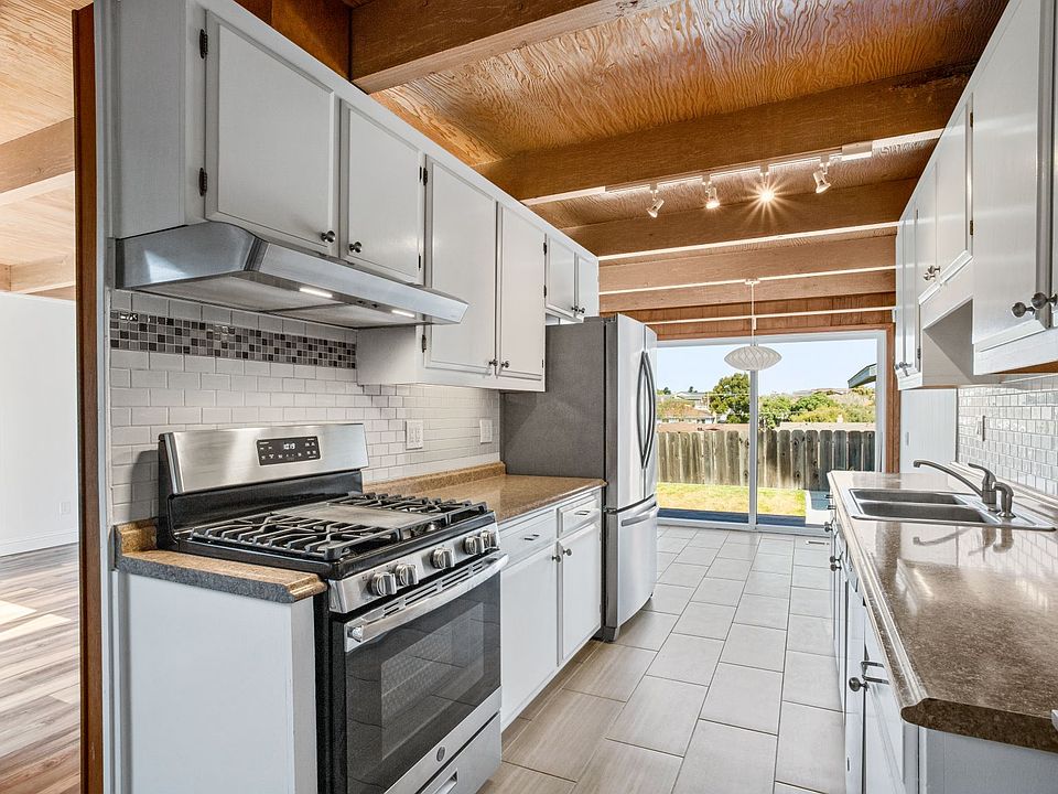 The galley kitchen features stainless appliances and a view to the backyard