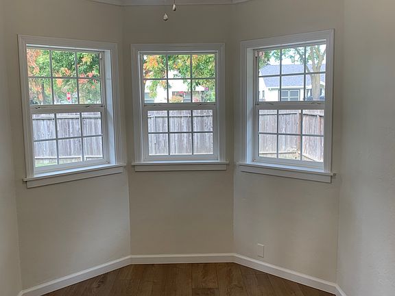 Bright, charming dining room with lots of outdoor lighting and a view into the backyard.