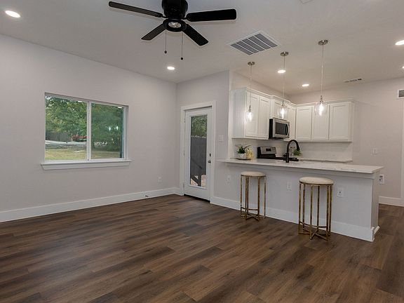 Great Room with breakfast bar, Wifi thermostat, ceiling fan, pendant lighting, exterior back door