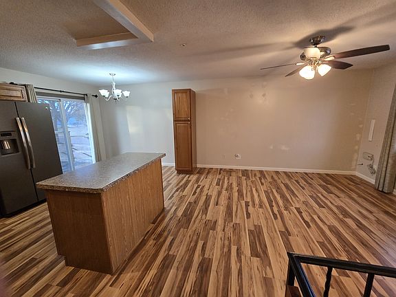 From top of stairs, view into kitchen, dining and living area. Very open. Pretty Hickory laminate flooring. Cieling fan for the living room.