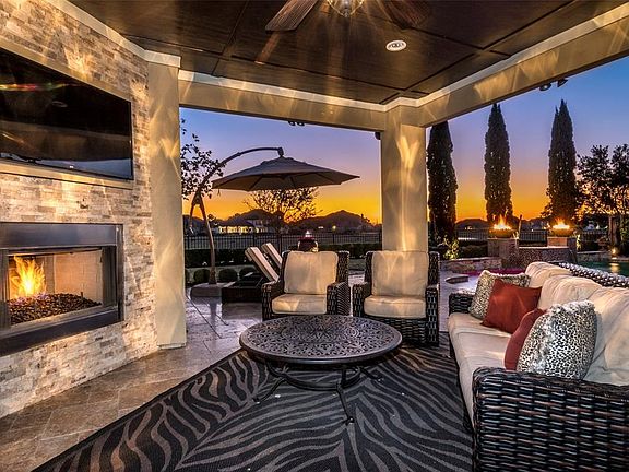 Wonderful outdoor living area! This space offers a stacked stone gas fireplace with television, outdoor kitchen, crown molding and lovely views of the pool.