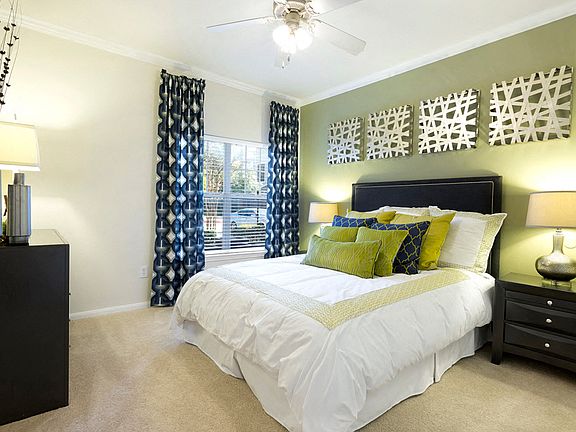 Bedroom with ceiling fan and plush carpet