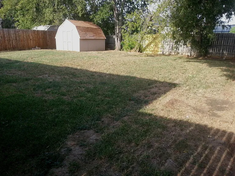 Large fenced backyard with storage shed