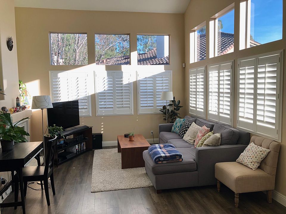 Living room with beautiful vaulted ceilings, natural lighting, and a fireplace.