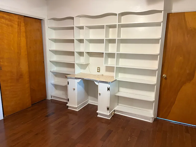 Bedroom with built in desk and book shelves