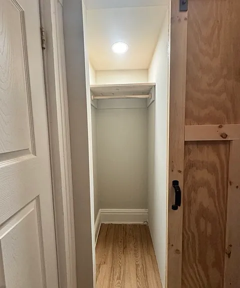 A small closet in the second bedroom on the main floor with a barn door.