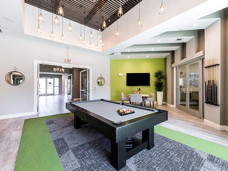 Game lounge with modern light fixture and seating area with cable TV