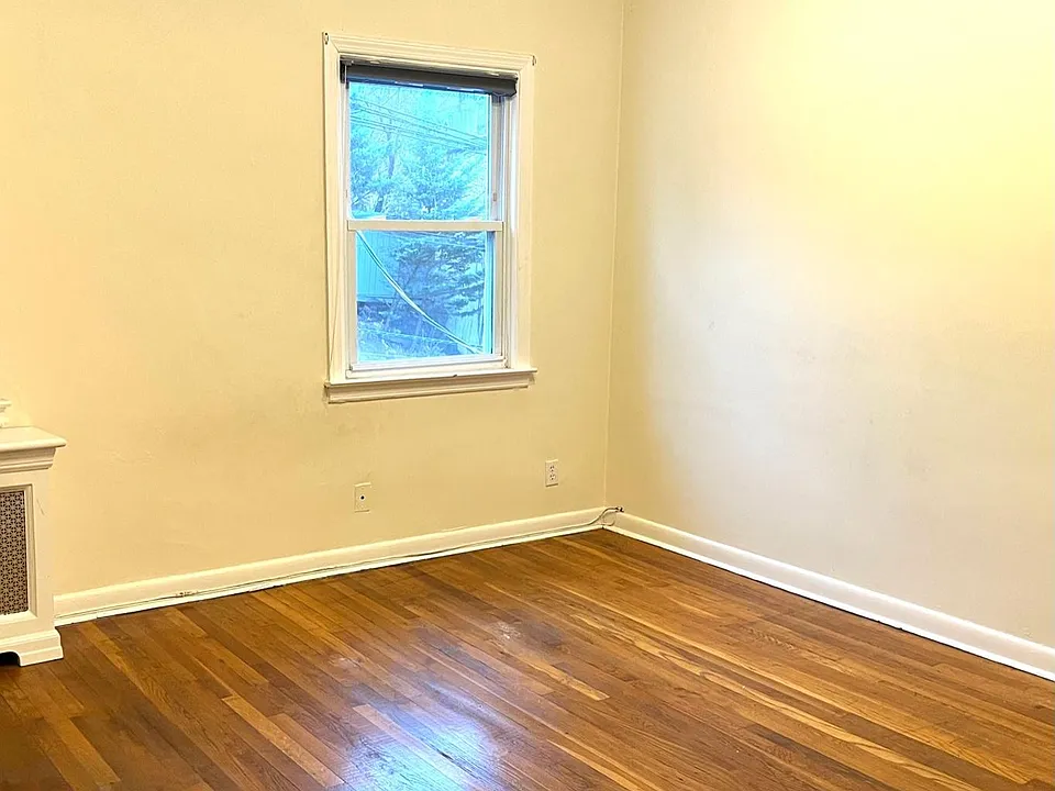 Another view of sunny bedroom with 2 windows.