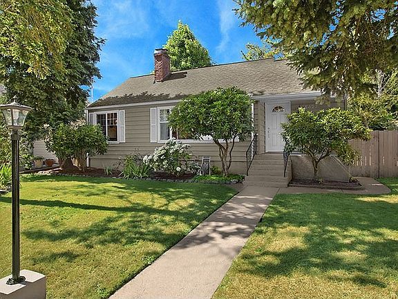 Beautiful Cape Cod nestled behind formal boxwood hedek