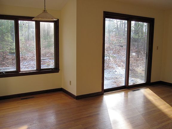 View from living room and dining area to the wooded backyard