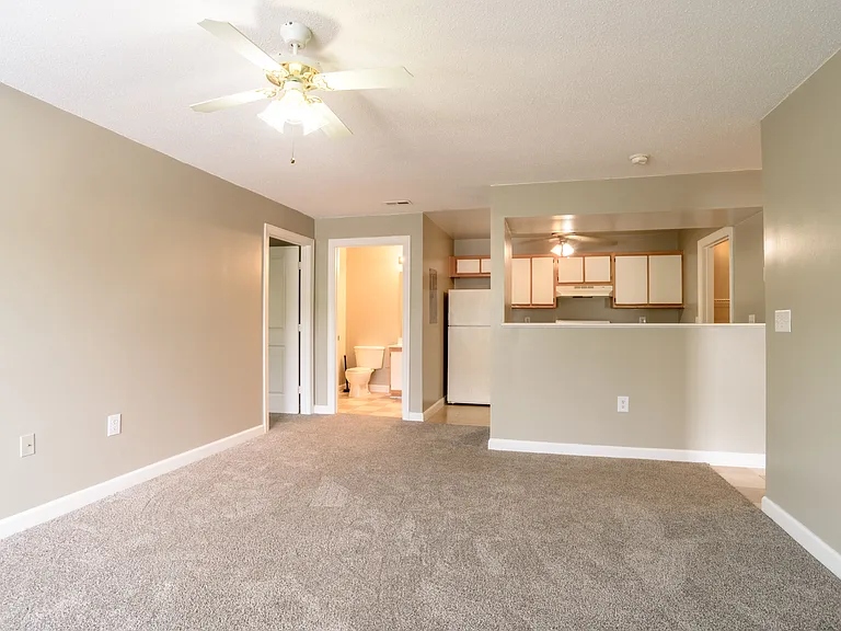 Open-concept living with cozy carpeting, ceiling fan, and breakfast bargreat for relaxing, entertaining, or easy everyday living.