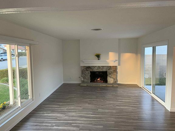 Formal Living Room with Gas Burning Fireplace. Sliding Glass Doors onto Backyard Patio.