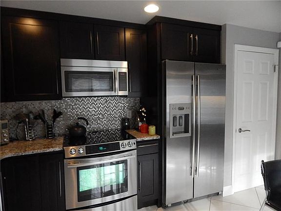 Kitchen with hard surface countertops, ceramic tile flooring.