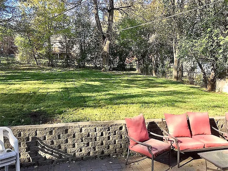 View of the patio and deep, fenced back yard.