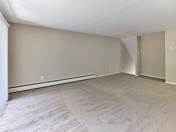 Spacious living room with plush carpet and open layout at Maple Terrace Apartments in Maple Shade, NJ