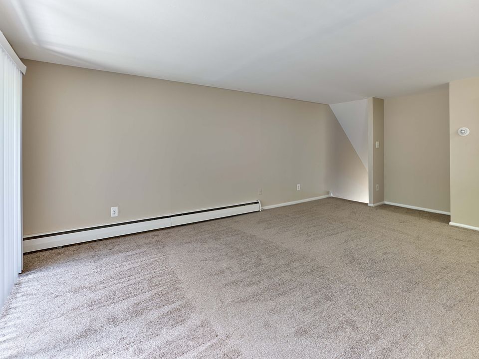 Spacious living room with plush carpet and open layout at Maple Terrace Apartments in Maple Shade, NJ