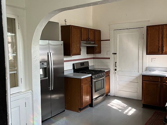 Kitchen with huge butlers pantry. New Stainless Refrigerator . Stainless gas stove. Stainless restaurant style kitchen faucet. Stainless dishwasher. Door to separate laundry with washer and dryer hookups.