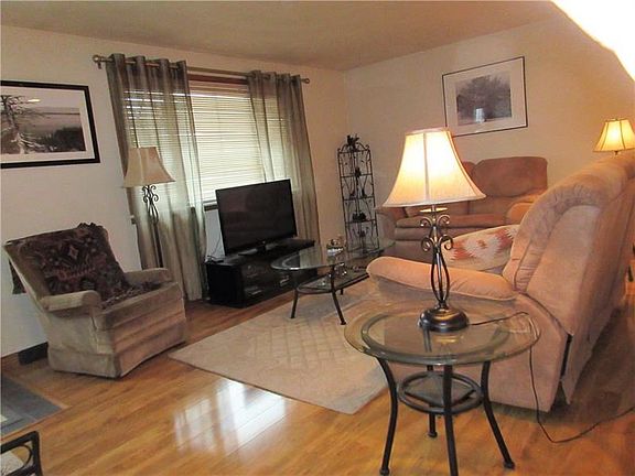 Living room has a large picture window for lots of natural light and gleaming wood laminate floor.