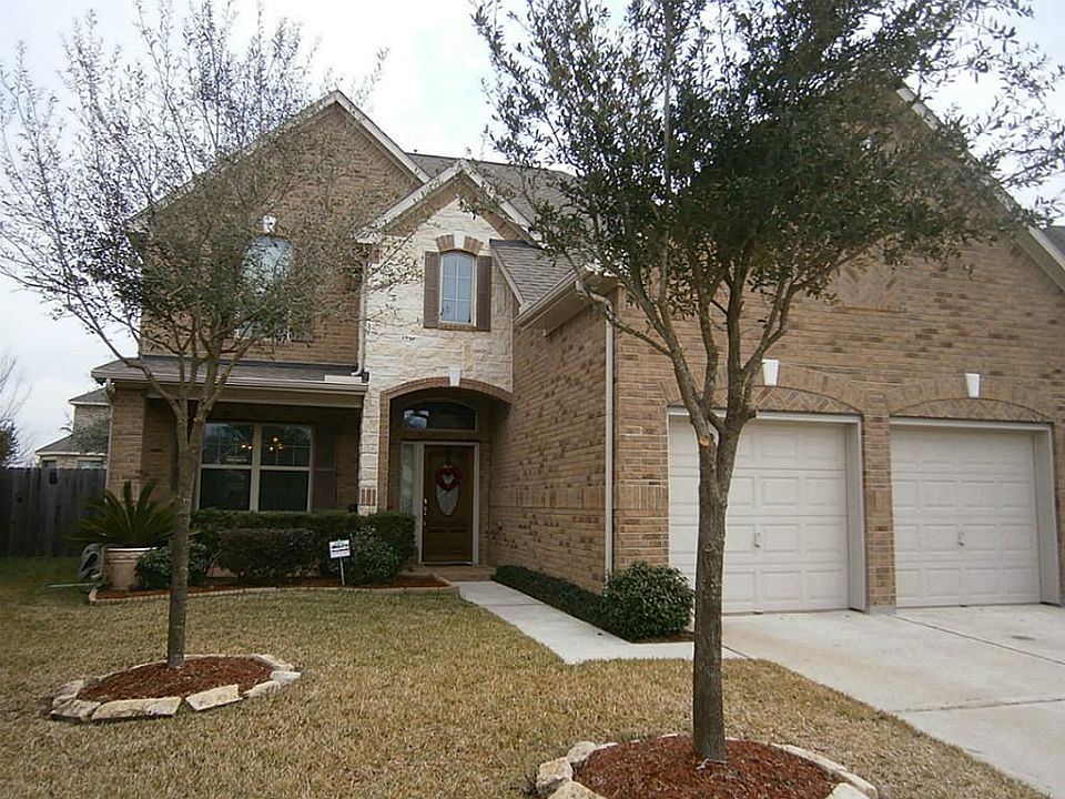 Front of house with a two car attached garage. The house is located on a nicely landscaped cul-de-sa